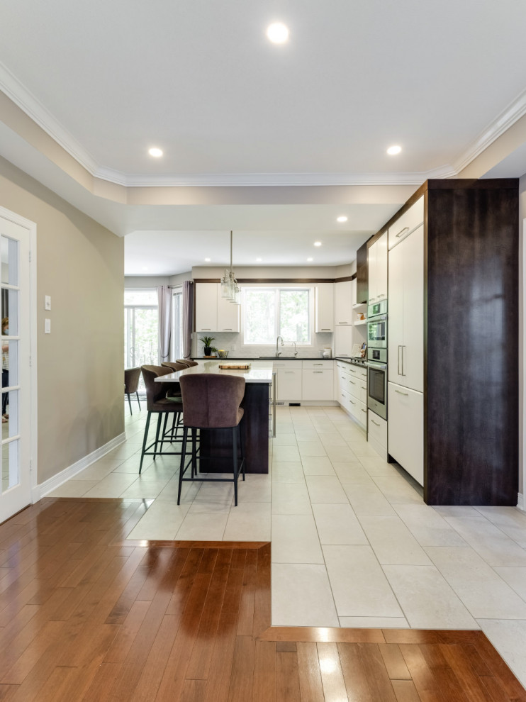 Inspiration for a contemporary kitchen in Ottawa with an integrated sink, flat-panel cabinets, white cabinets, engineered stone countertops, white splashback, mosaic tiled splashback, an island and white worktops.