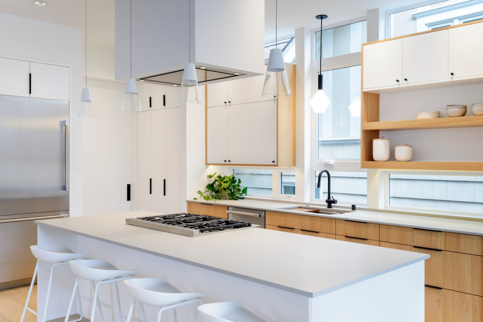 Mid-sized trendy galley light wood floor open concept kitchen photo in Seattle with an undermount sink, flat-panel cabinets, white cabinets, quartz countertops, window backsplash, stainless steel appliances, an island and white countertops