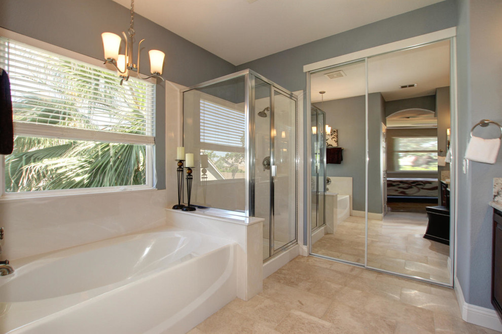 Transitional bathroom in Sacramento with raised-panel cabinets, dark wood cabinets, granite benchtops, a freestanding tub, an alcove shower, beige tile and stone tile.