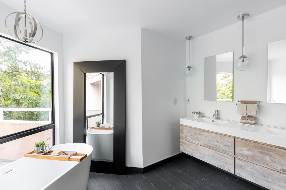 Photo of a mid-sized modern master bathroom in San Francisco with raised-panel cabinets, distressed cabinets, a freestanding tub, a corner shower, a two-piece toilet, gray tile, ceramic tile, a wall-mount sink, solid surface benchtops, an open shower, white benchtops, white walls, ceramic floors and black floor.