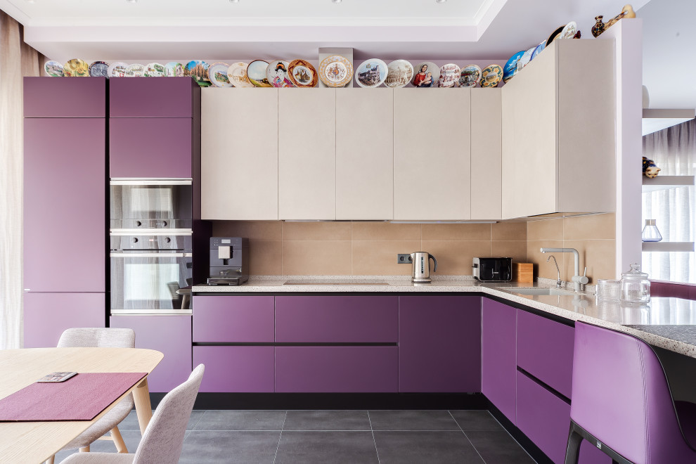 Photo of a mid-sized contemporary l-shaped eat-in kitchen in Moscow with an undermount sink, flat-panel cabinets, purple cabinets, beige splashback, porcelain splashback, panelled appliances, porcelain floors, a peninsula, grey floor and beige benchtop.