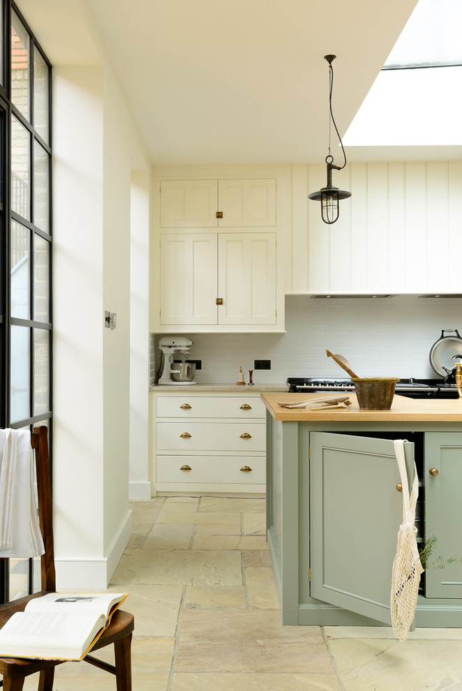 Design ideas for a large traditional open plan kitchen in Other with a farmhouse sink, beaded inset cabinets, white cabinets, wood benchtops, white splashback, subway tile splashback, black appliances and with island.
