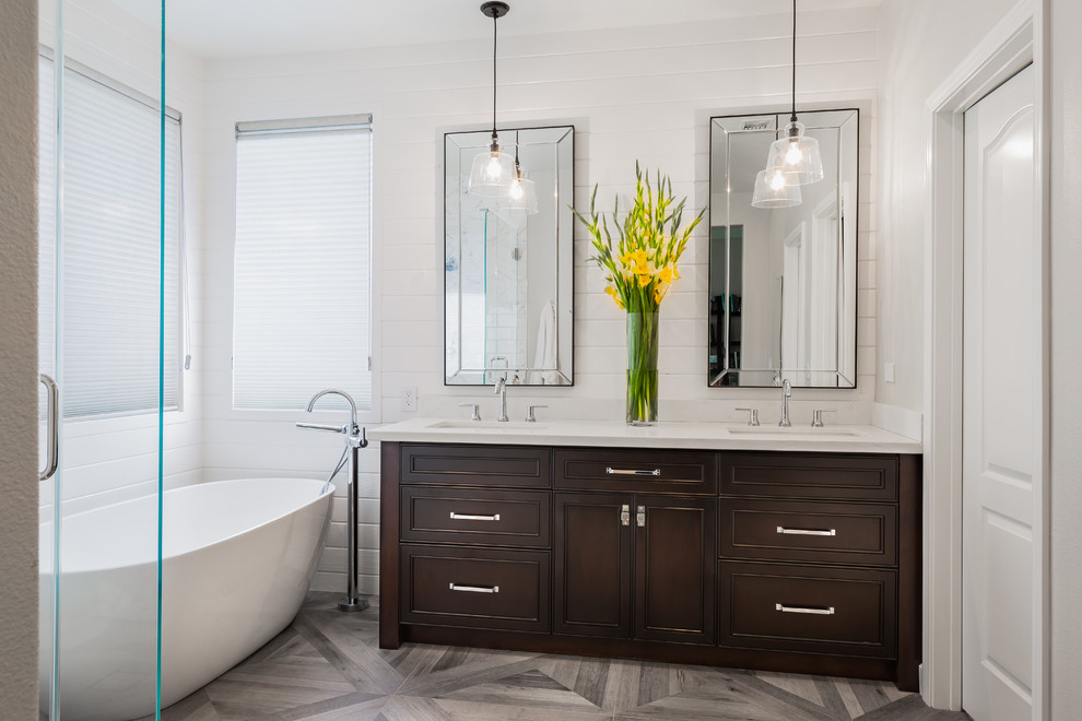 Photo of a mid-sized contemporary master bathroom in Los Angeles with furniture-like cabinets, dark wood cabinets, a freestanding tub, a corner shower, grey walls, an undermount sink, engineered quartz benchtops, grey floor, a hinged shower door and white benchtops.