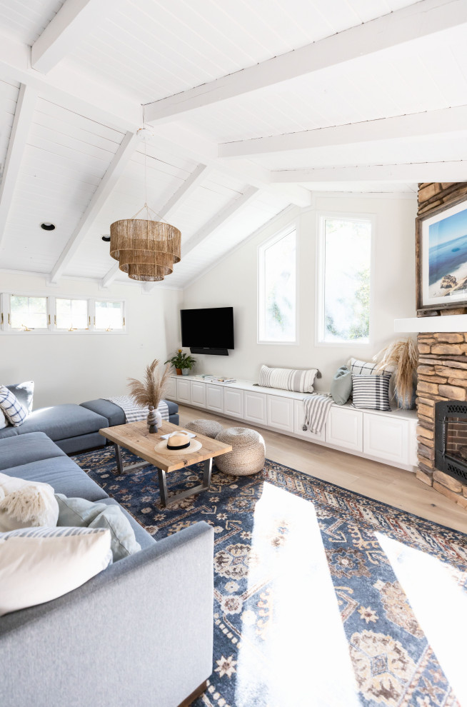サンフランシスコにある高級な広いビーチスタイルのおしゃれなLDK (白い壁、石材の暖炉まわり、壁掛け型テレビ) の写真