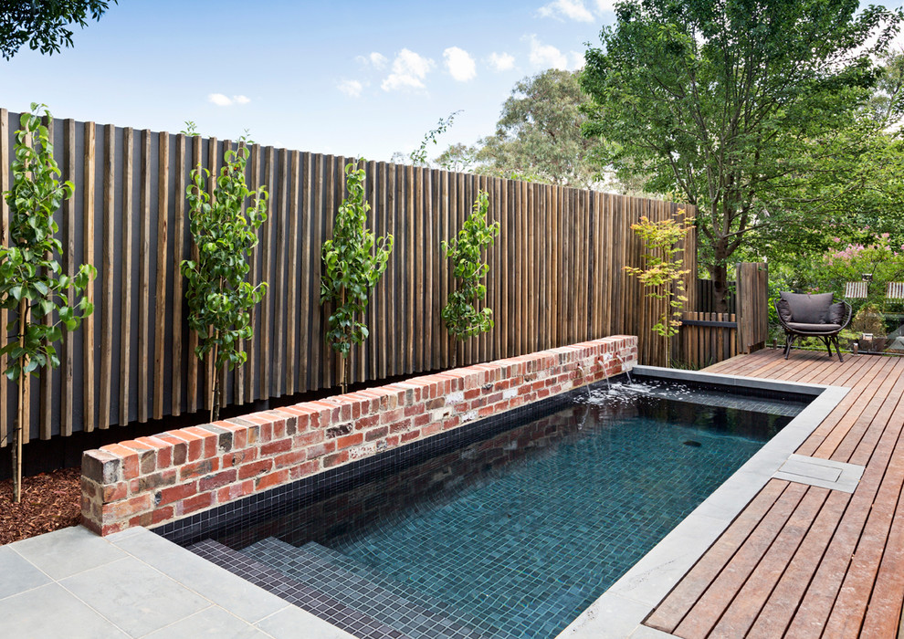Small contemporary rectangular aboveground pool in Melbourne with a water feature and decking.