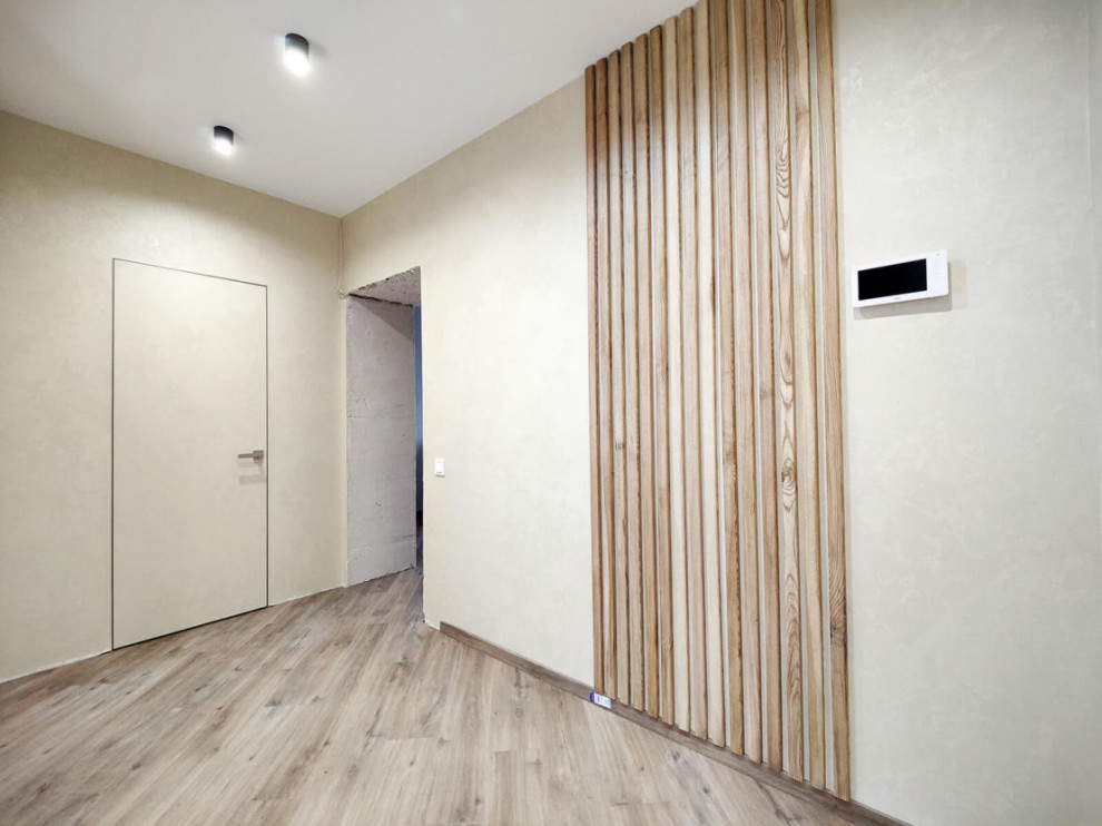 Idée de décoration pour un couloir design de taille moyenne avec un mur beige, sol en stratifié, un sol beige et du papier peint.