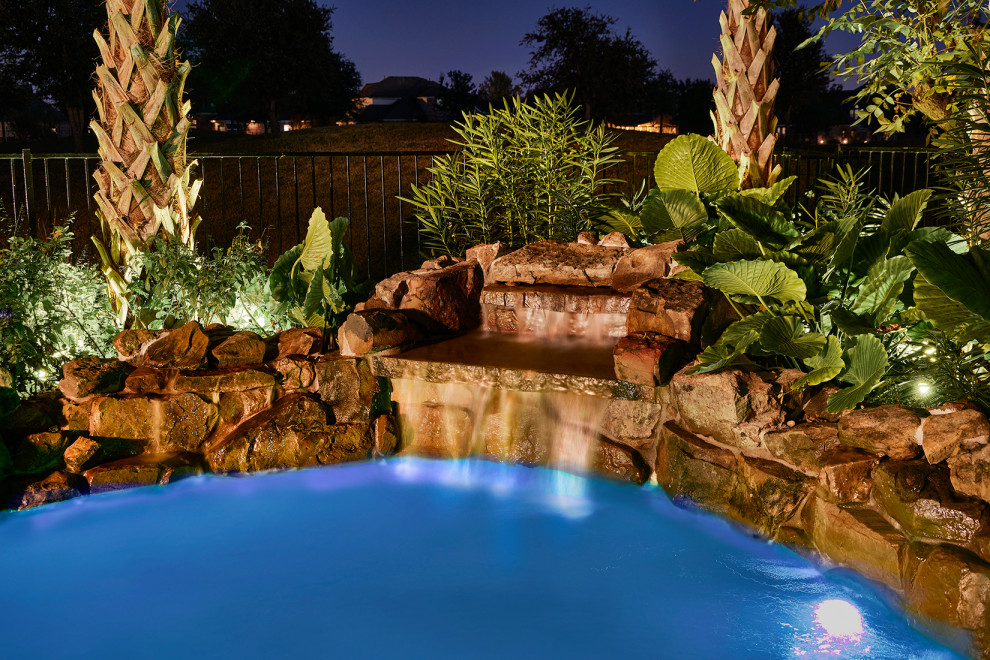 Cette photo montre un piscine avec aménagement paysager arrière exotique de taille moyenne et sur mesure avec des pavés en pierre naturelle.