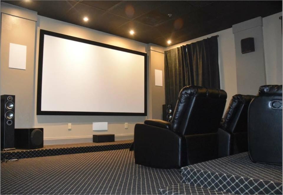 Mid-sized transitional enclosed home theatre in Atlanta with white walls, carpet, a projector screen and black floor.