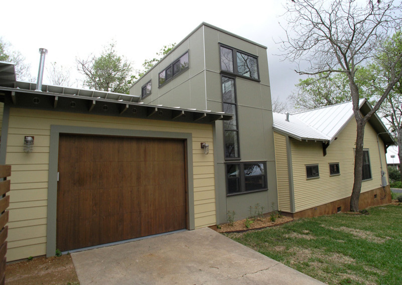 Photo of a mid-sized modern one-storey house exterior in Kansas City with mixed siding, a gable roof and a metal roof.
