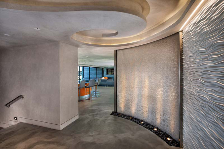 Large contemporary foyer in Los Angeles with metallic walls and concrete floors.
