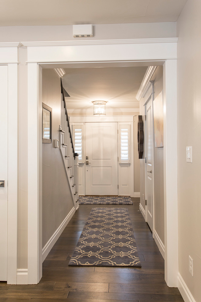 Large transitional medium tone wood floor and brown floor foyer photo in Denver with gray walls and a white front door