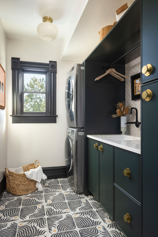 Dedicated laundry room - mid-sized eclectic galley ceramic tile and multicolored floor dedicated laundry room idea in Denver with an undermount sink, shaker cabinets, green cabinets, quartz countertops, ceramic backsplash, white walls, a stacked washer/dryer and white countertops