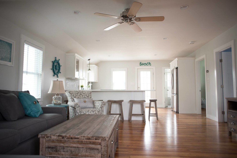 Mid-sized beach style formal open concept living room in Providence with white walls, light hardwood floors and a wall-mounted tv.