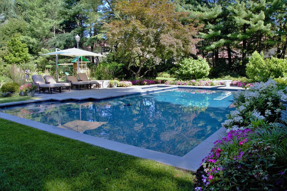 Design ideas for a large contemporary backyard custom-shaped lap pool in New York with a hot tub and concrete pavers.