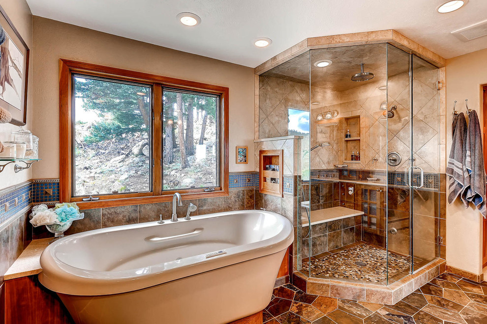 Large country master bathroom in Denver with flat-panel cabinets, light wood cabinets, a freestanding tub, a double shower, blue tile, mosaic tile, beige walls, concrete floors, an undermount sink and limestone benchtops.