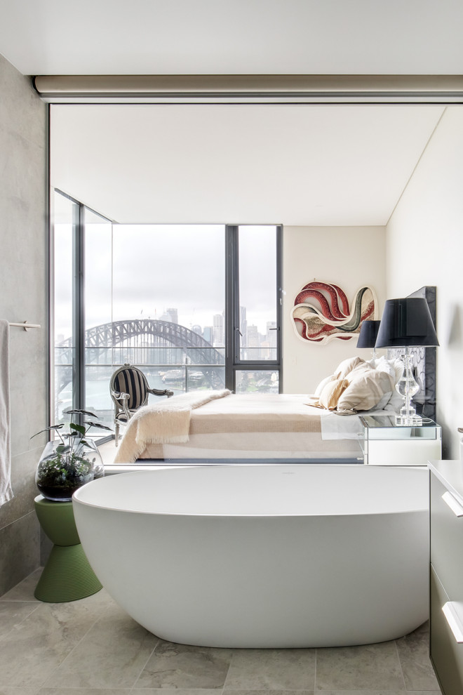 Mid-sized contemporary 3/4 bathroom in Sydney with flat-panel cabinets, grey cabinets, a freestanding tub, a one-piece toilet, gray tile, porcelain tile, grey walls, porcelain floors, a vessel sink, engineered quartz benchtops, grey floor, white benchtops, a double vanity, a floating vanity, a corner shower and a hinged shower door.