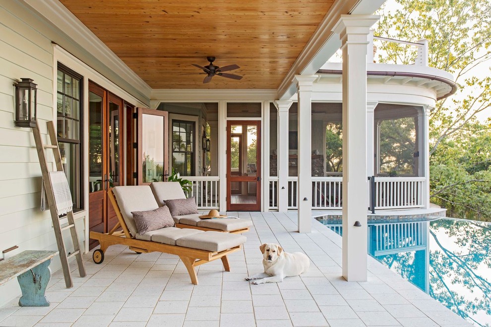Inspiration for a beach style verandah in Charleston with a water feature, tile and a roof extension.