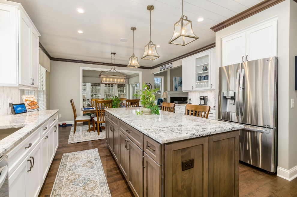 This is an example of a large transitional u-shaped eat-in kitchen in Columbus with shaker cabinets, granite benchtops, marble splashback and with island.