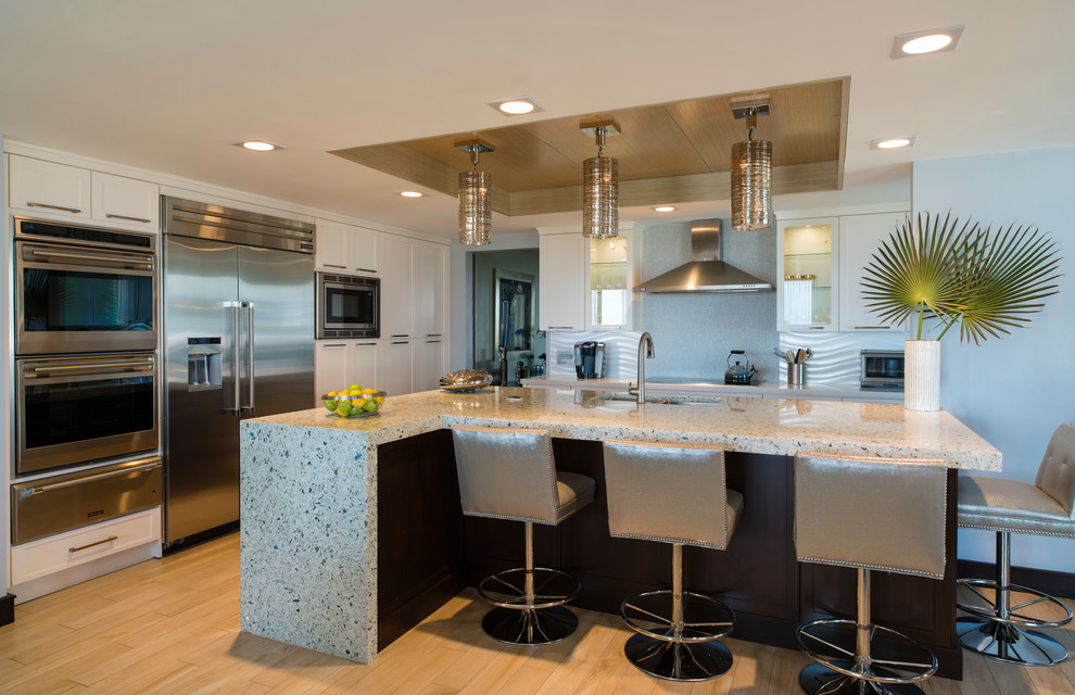 Large contemporary l-shaped open plan kitchen in Miami with an undermount sink, shaker cabinets, terrazzo benchtops, grey splashback, ceramic splashback, stainless steel appliances, porcelain floors and with island.