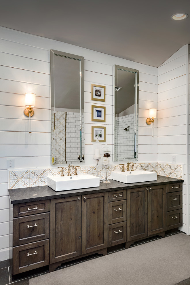 Large transitional master bathroom in Phoenix with shaker cabinets, dark wood cabinets, a curbless shower, white tile, subway tile, grey walls, limestone floors, a vessel sink, limestone benchtops, a freestanding tub and an open shower.