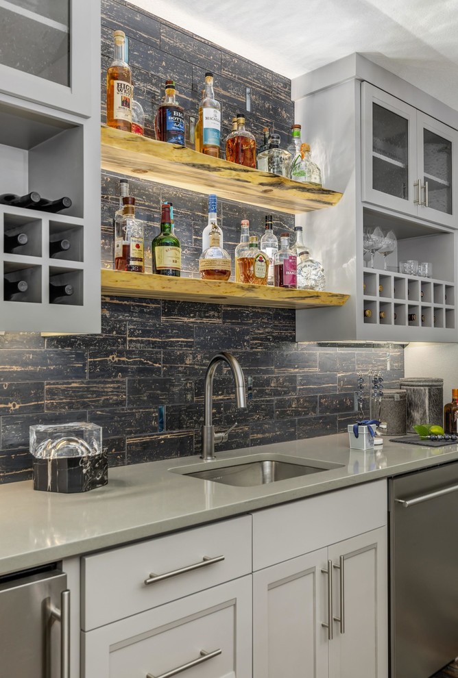 Design ideas for a mid-sized contemporary single-wall wet bar in Portland with an undermount sink, shaker cabinets, quartzite benchtops, black splashback, subway tile splashback, vinyl floors, grey benchtop and brown floor.
