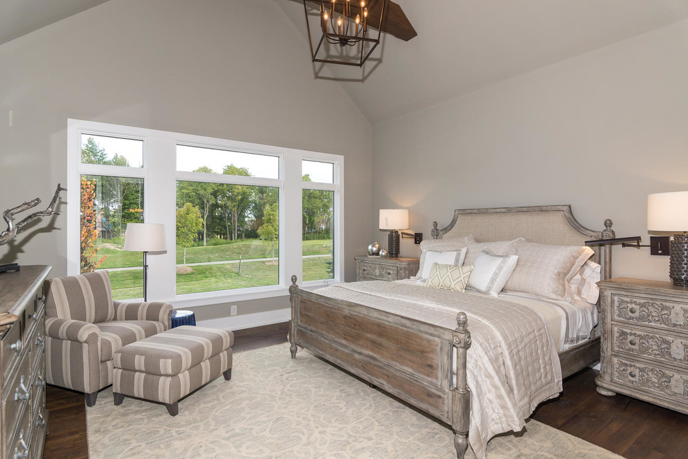 This is an example of a mid-sized country master bedroom in Indianapolis with grey walls, medium hardwood floors, no fireplace and brown floor.