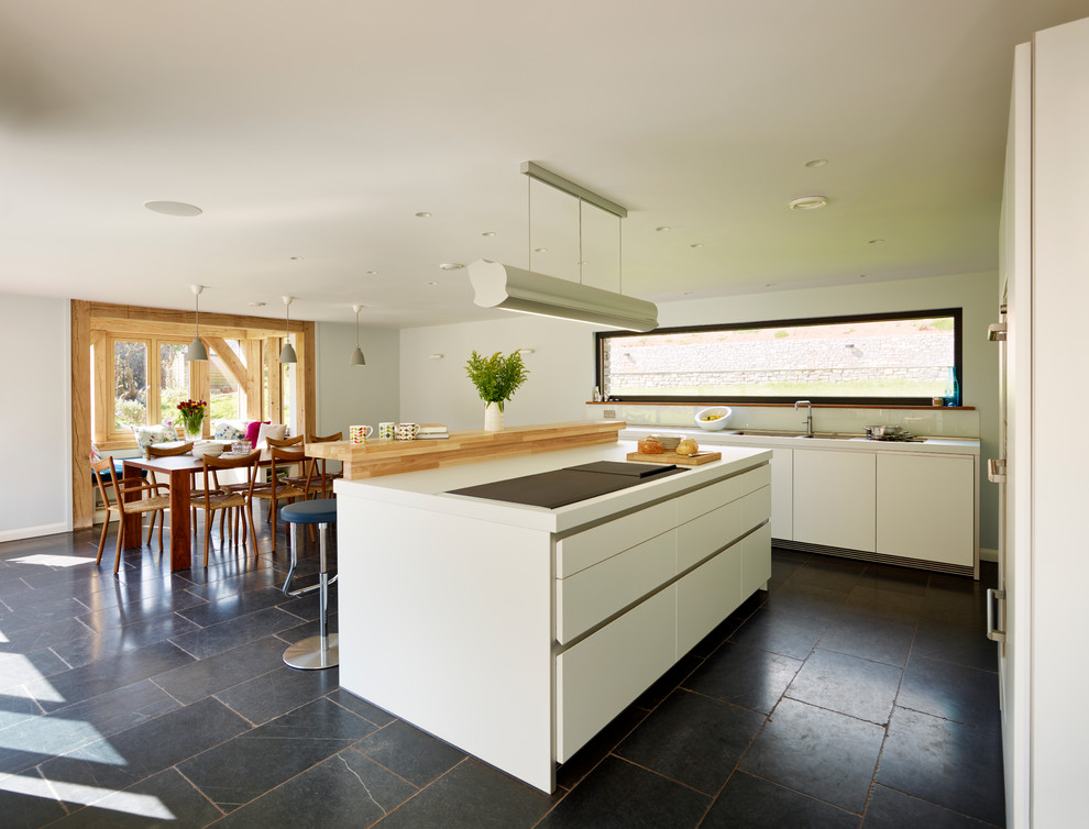 Design ideas for a contemporary kitchen in Devon with white cabinets, laminate benchtops and slate floors.