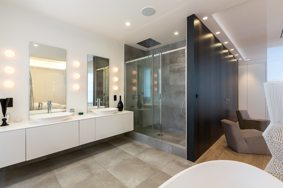 Inspiration for a large contemporary master bathroom in Paris with flat-panel cabinets, white cabinets, a freestanding tub, an alcove shower, brown tile, white walls, a vessel sink and a sliding shower screen.