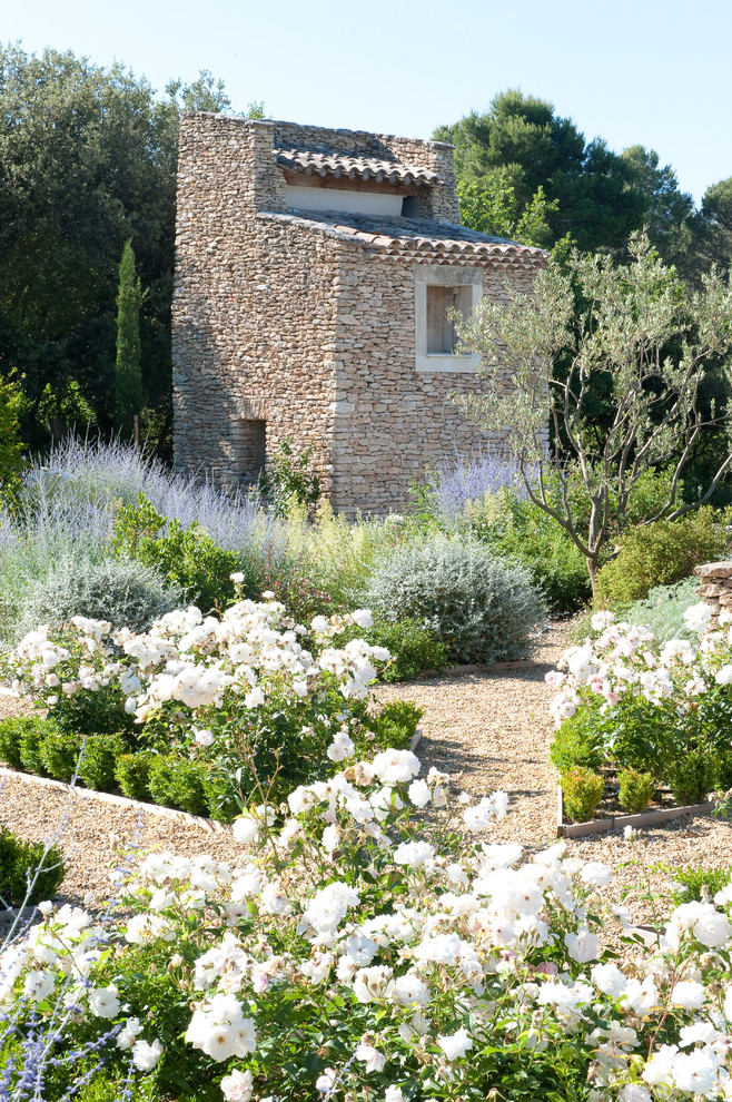 Inspiration for a mid-sized mediterranean garden in Other with gravel.