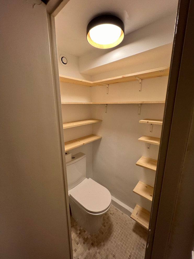 Foto på ett litet funkis beige en-suite badrum, med beige skåp, en kantlös dusch, en vägghängd toalettstol, vit kakel, stenkakel, vita väggar, mosaikgolv, ett fristående handfat, träbänkskiva, beiget golv och med dusch som är öppen