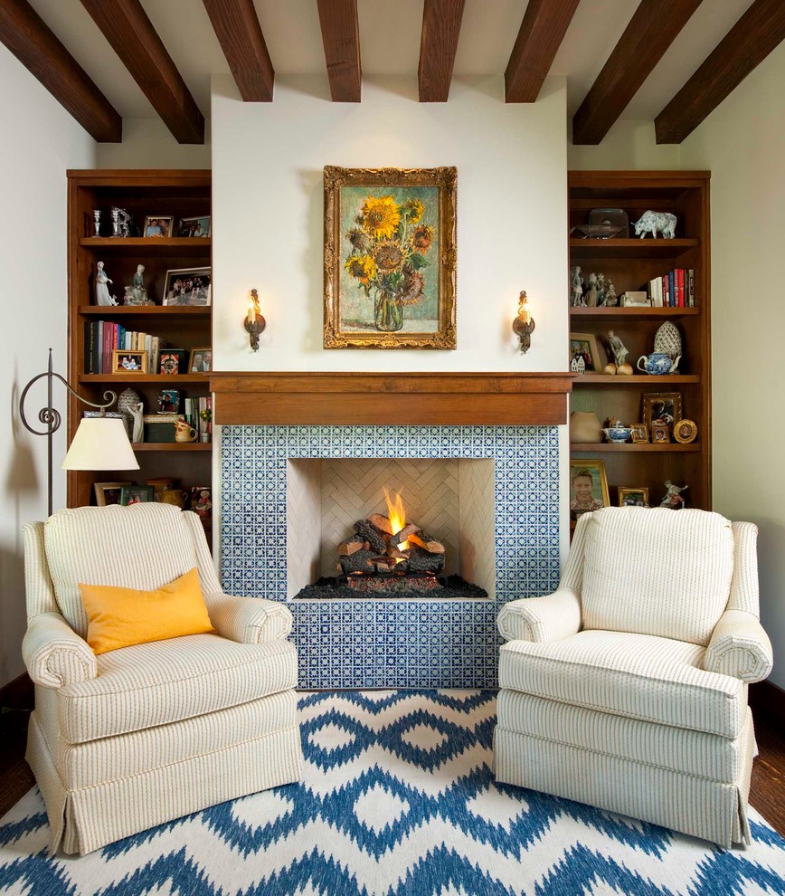 This is an example of a mediterranean study room in San Diego with white walls, medium hardwood floors, a standard fireplace, a tile fireplace surround and a freestanding desk.