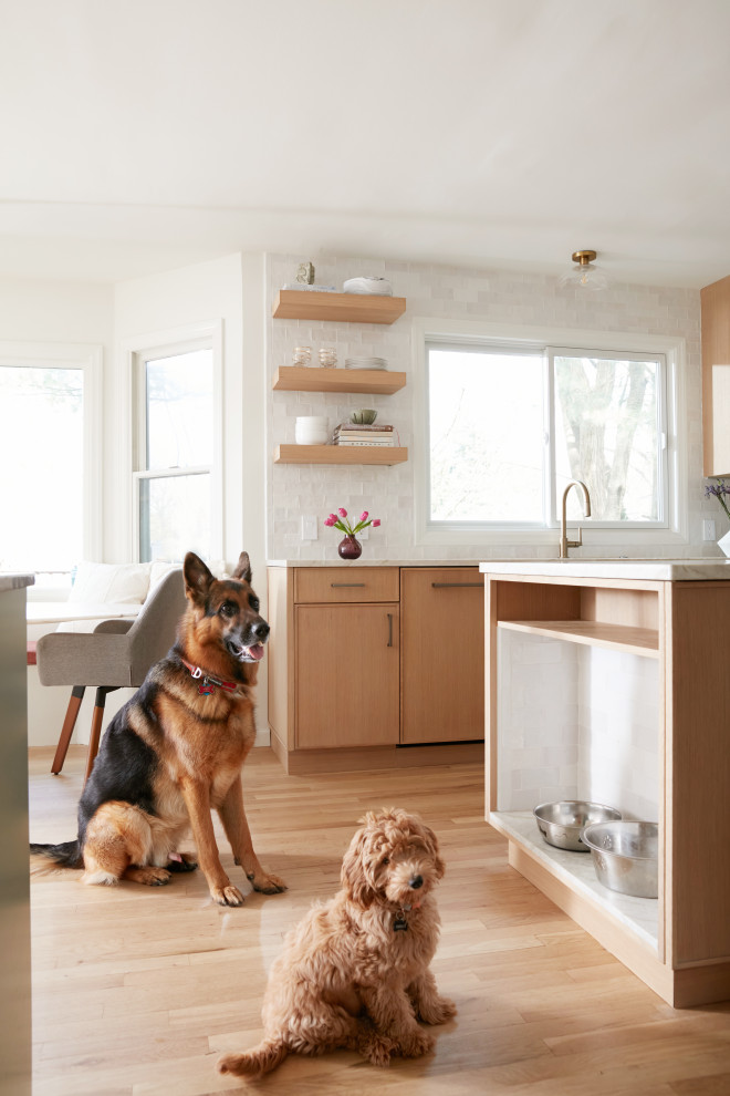 Example of an u-shaped light wood floor eat-in kitchen design in New York with an undermount sink, marble countertops, beige backsplash, ceramic backsplash, stainless steel appliances and beige countertops