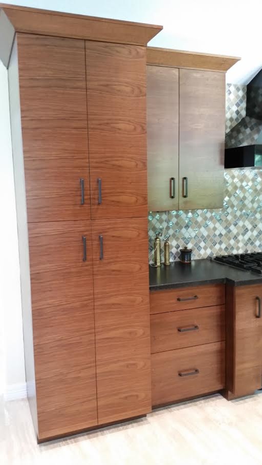 Open concept kitchen - mid-sized transitional light wood floor and beige floor open concept kitchen idea in Houston with flat-panel cabinets, medium tone wood cabinets, solid surface countertops, multicolored backsplash, glass tile backsplash, stainless steel appliances and no island