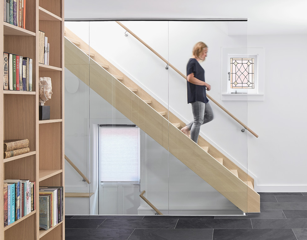 Design ideas for a scandinavian wood straight staircase in Toronto with glass railing.