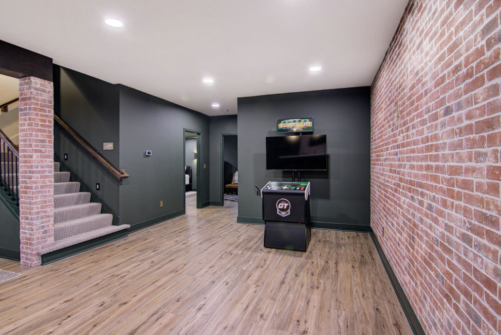 Inspiration for a large modern walk-out basement in Kansas City with a home bar, green walls, vinyl flooring, exposed beams and brick walls.