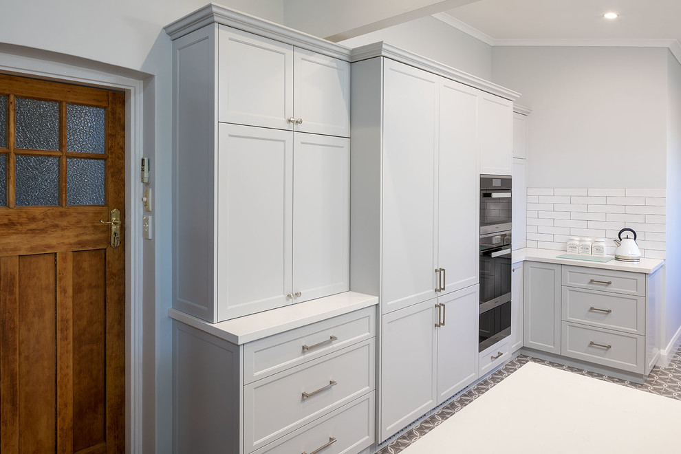 Inspiration for a traditional kitchen in Perth with shaker cabinets, grey cabinets, quartz benchtops, white splashback, subway tile splashback, panelled appliances, ceramic floors, multi-coloured floor and white benchtop.