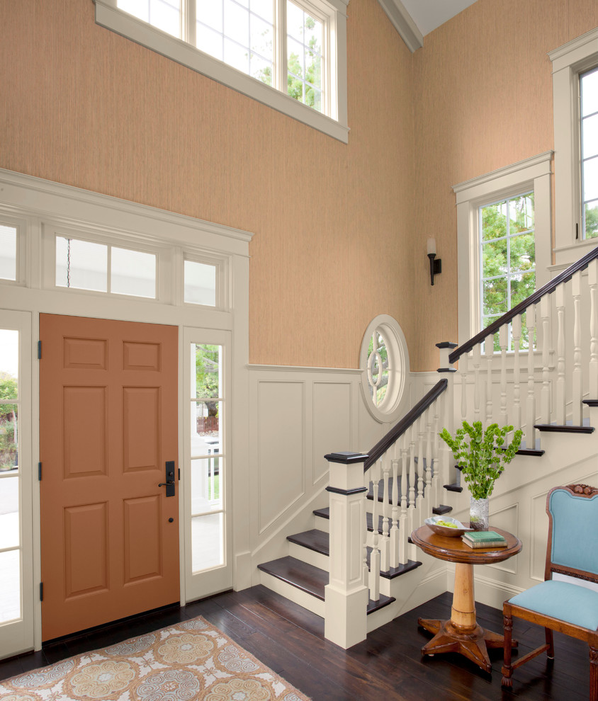 Design ideas for a large transitional foyer in Charlotte with brown walls, dark hardwood floors, a single front door and a red front door.
