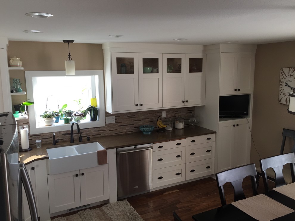 Small country l-shaped kitchen in Other with a farmhouse sink, shaker cabinets, white cabinets, beige splashback, stainless steel appliances and no island.