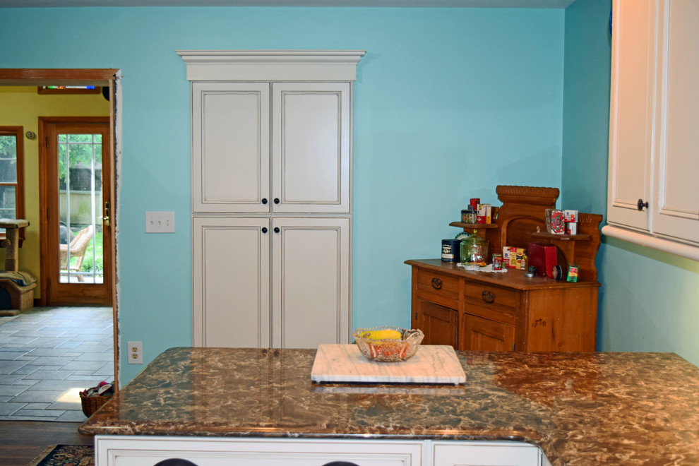 Example of a transitional kitchen design with an undermount sink, raised-panel cabinets, quartz countertops, beige backsplash, subway tile backsplash, stainless steel appliances and a peninsula