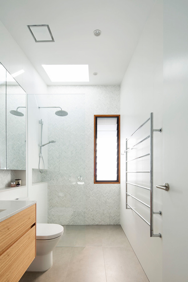 Modern bathroom in Sydney with flat-panel cabinets, medium wood cabinets, an open shower, a one-piece toilet, gray tile, marble, white walls, ceramic floors, an undermount sink, engineered quartz benchtops, grey floor and an open shower.