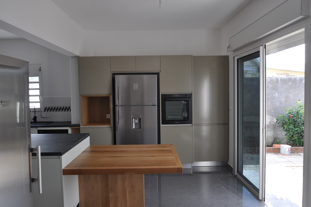 Design ideas for a mid-sized contemporary l-shaped open plan kitchen in Other with an undermount sink, flat-panel cabinets, white cabinets, laminate benchtops, white splashback, ceramic splashback, white appliances, ceramic floors, with island, grey floor and grey benchtop.