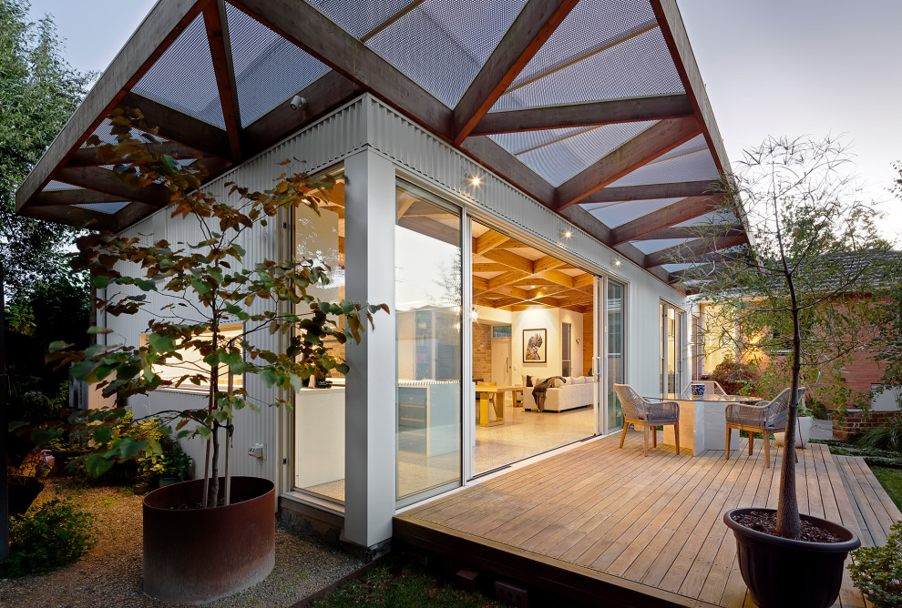 Foto di una terrazza minimalista di medie dimensioni, dietro casa e a piano terra con un tetto a sbalzo e parapetto in materiali misti