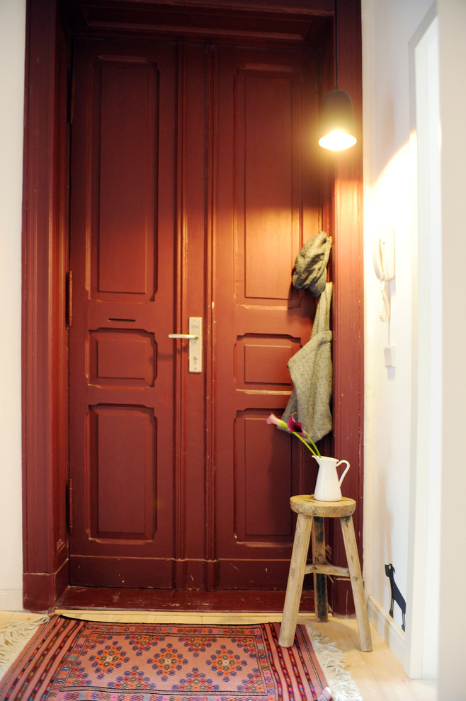 Inspiration for a mid-sized traditional entryway in Berlin with white walls and light hardwood floors.