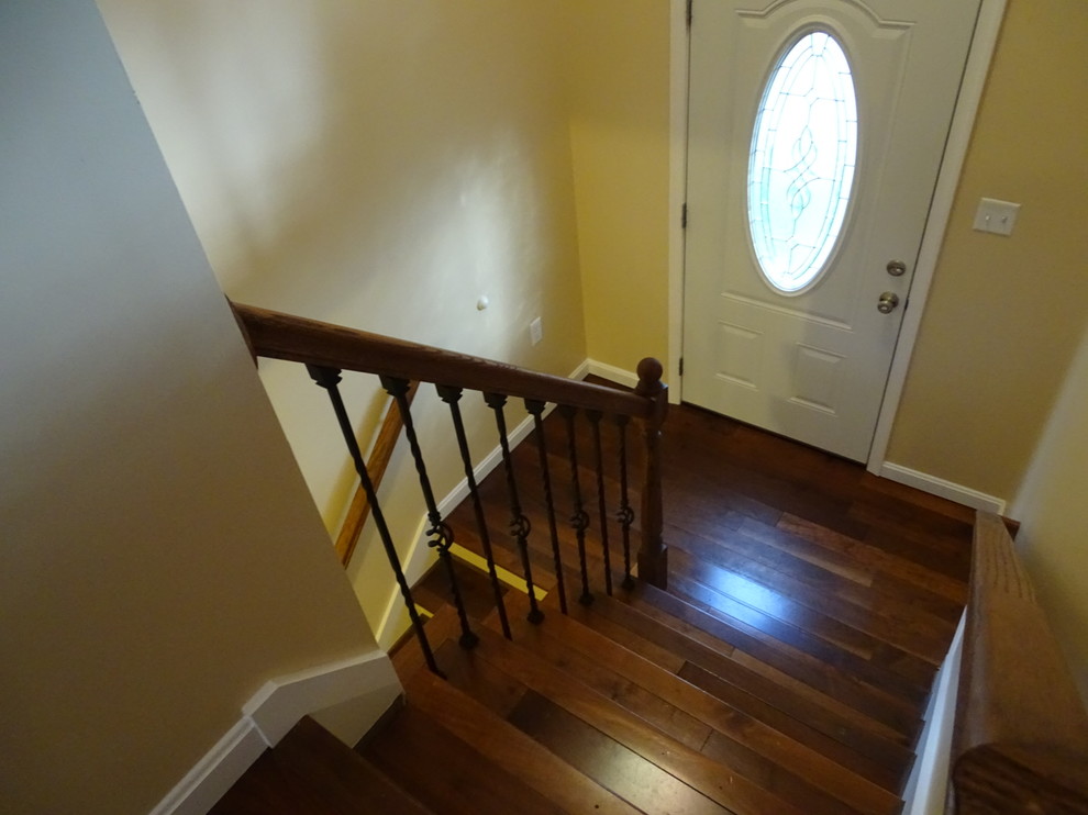 Example of a mid-sized classic medium tone wood floor and brown floor front door design with yellow walls and a metal front door