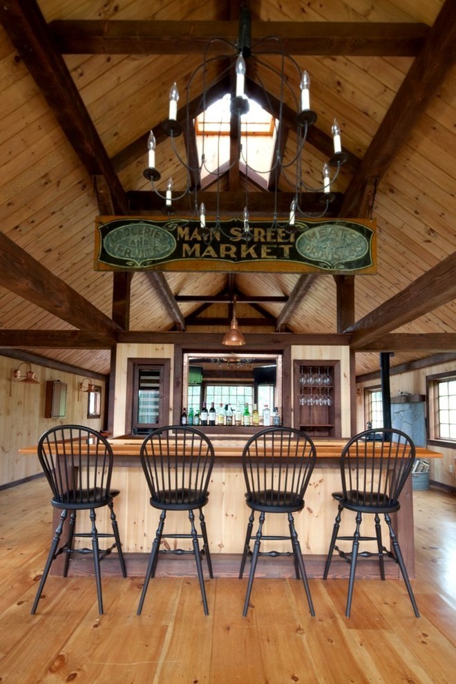 Photo of a country seated home bar in Manchester with medium hardwood floors and wood benchtops.