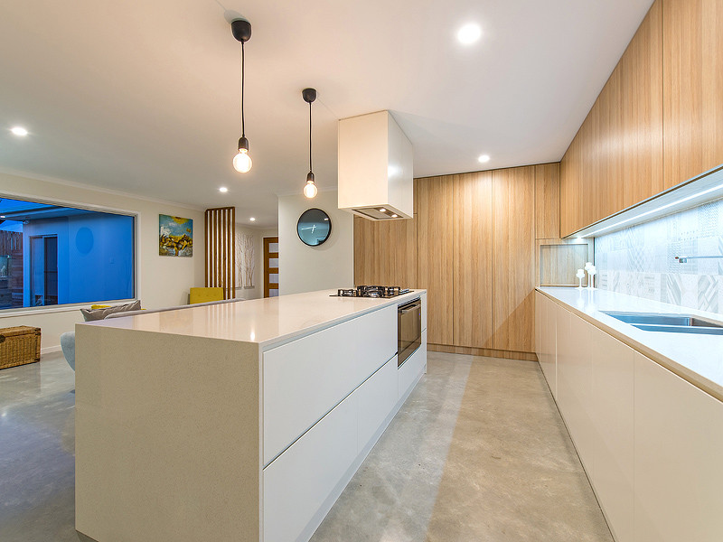 Scandinavian kitchen in Sunshine Coast with a drop-in sink, light wood cabinets, quartz benchtops, multi-coloured splashback, porcelain splashback, concrete floors and with island.