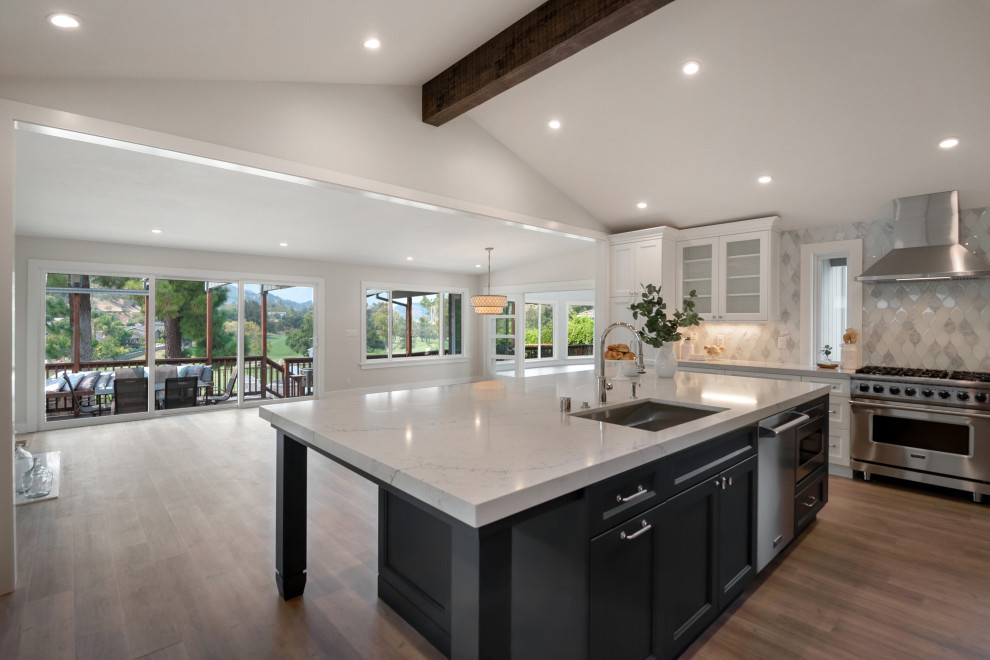 Inspiration for a transitional vaulted ceiling kitchen pantry remodel in San Francisco with recessed-panel cabinets, white cabinets, quartz countertops, white backsplash, glass tile backsplash, stainless steel appliances and white countertops