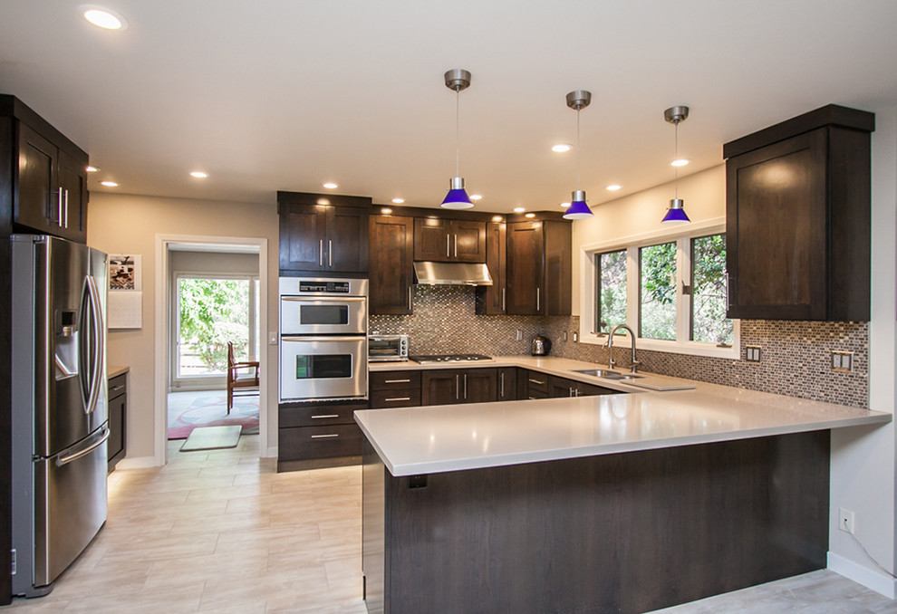 Mid-sized transitional u-shaped light wood floor and beige floor eat-in kitchen photo in Phoenix with an undermount sink, shaker cabinets, dark wood cabinets, granite countertops, multicolored backsplash, mosaic tile backsplash, stainless steel appliances and an island