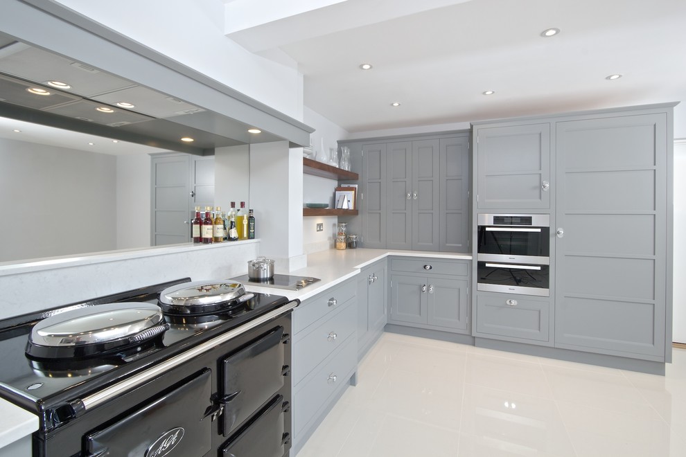 Mid-sized transitional l-shaped kitchen in Hampshire with recessed-panel cabinets, grey cabinets, limestone benchtops, mirror splashback, porcelain floors and white floor.