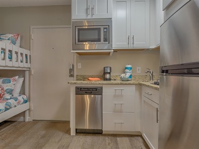 Eat-in kitchen - small coastal l-shaped porcelain tile eat-in kitchen idea with an undermount sink, shaker cabinets, white cabinets, granite countertops and no island